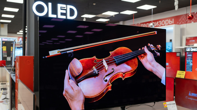 An OLED TV displaying a violin inside an electronics store