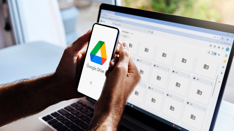 A man using Google Drive on his phone and laptop