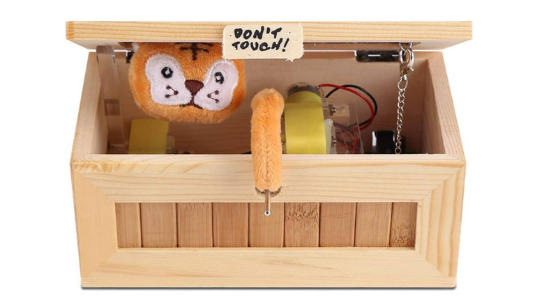 Small wooden box with a Don't Tough sign on it, opening to reveal a motor and a plush tiger arm