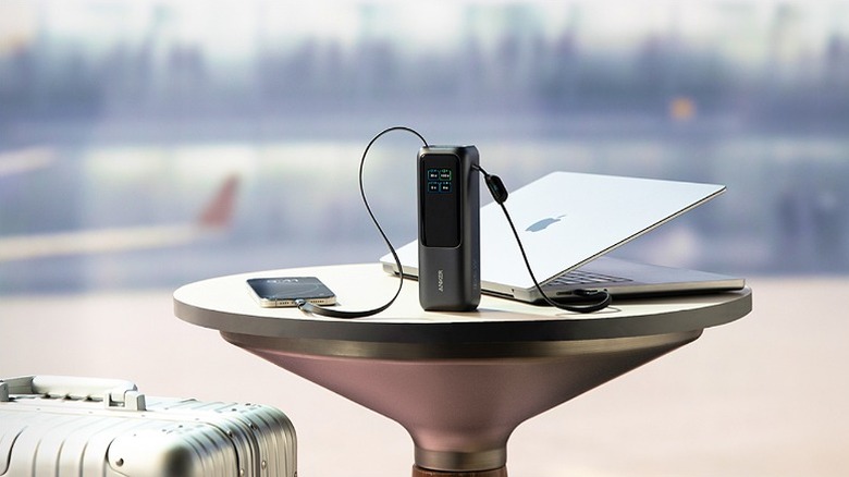 Power bank connected to a smartphone and laptop.