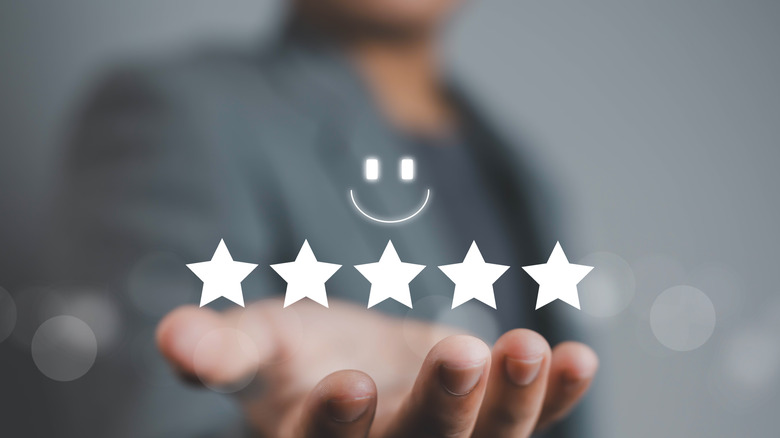 Holographic image of five star customer reviews and a happy face.