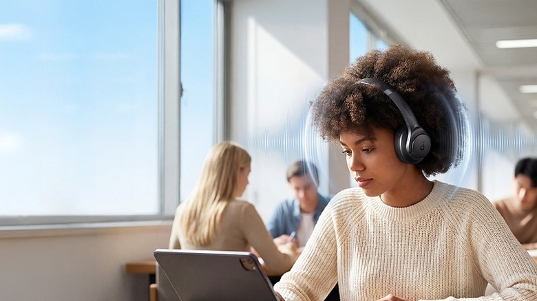 Woman wearing headphones working on a tablet.