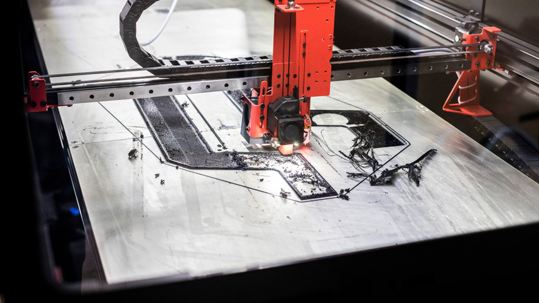 A massive 3D printer works on the early layers of a model.