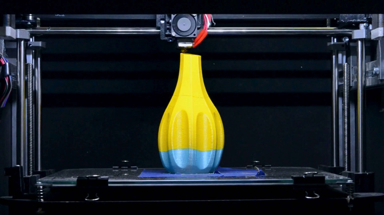 A 3D printer is making a multicolor vase.