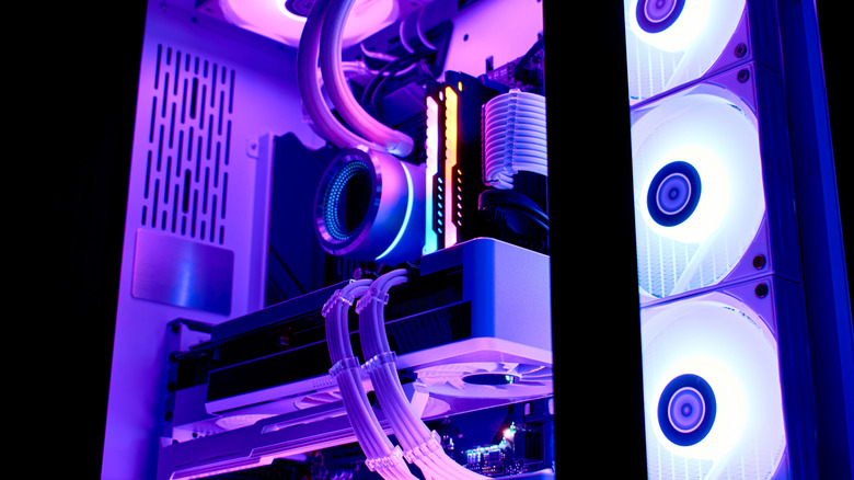 The interior of a gaming PC lit up with pink lights.