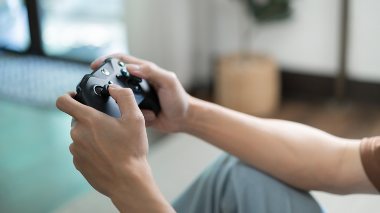 A person holds a video game controller with both hands.