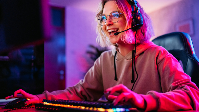 A woman playing a game on her desktop and smiling