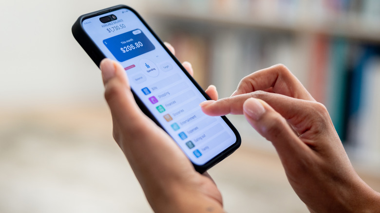 Person's hands using an online banking app on a smartphone