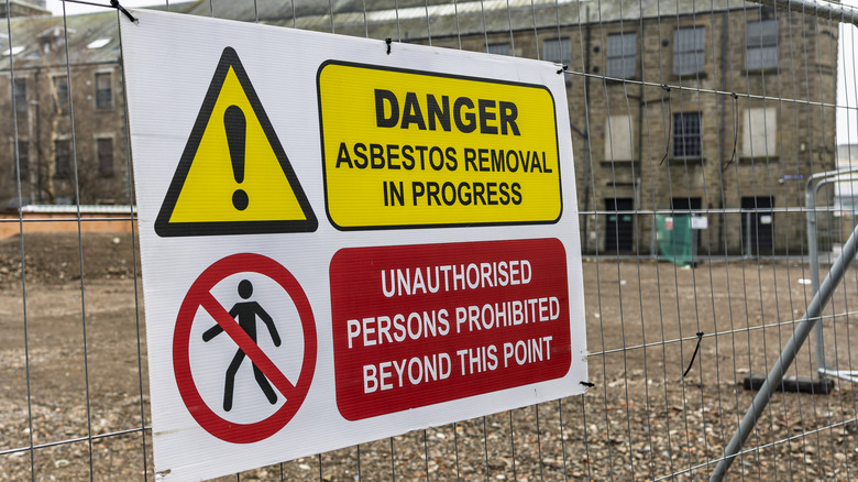 Warning sign showing asbestos removal from site