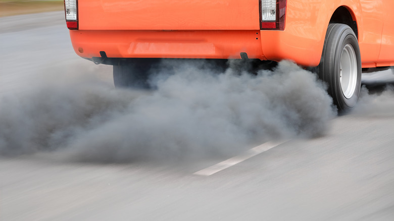 Red car emitting diesel exhaust fumes
