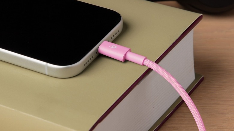 Beats charging cable in pink connected to iPhone