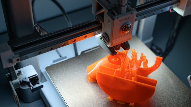 A 3D printer creating an orange model