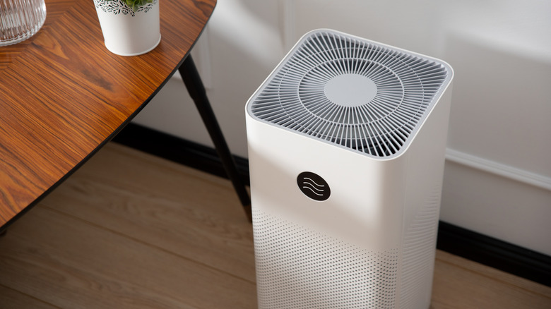 An air purifier placed next to a table