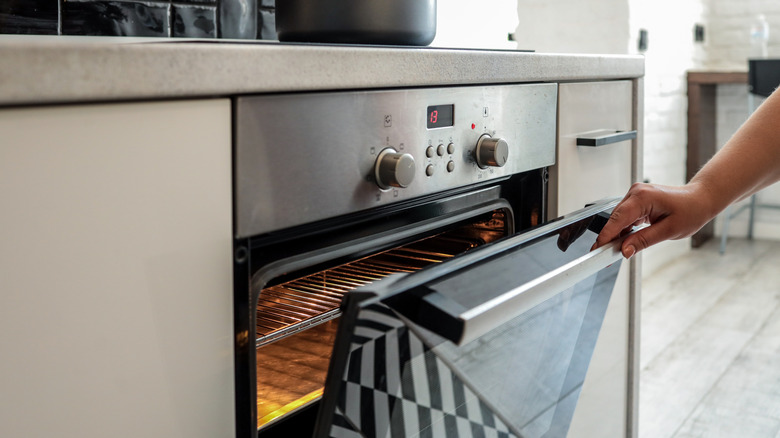 A person opening an oven