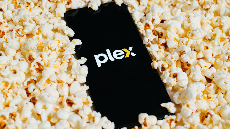 The Plex logo on a phone surrounded by popcorn