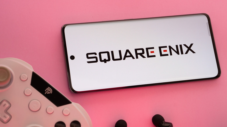 Square Enix logo on a phone in next to a controller