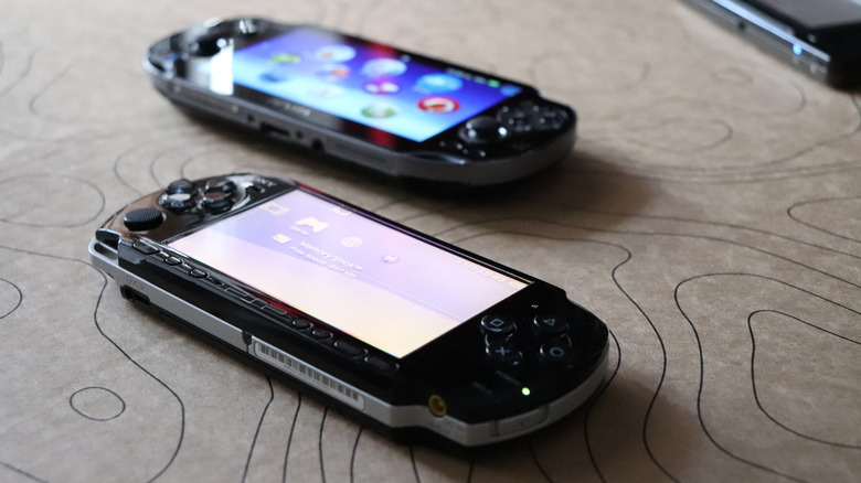 Two Sony PlayStation Portable handheld consoles on a table