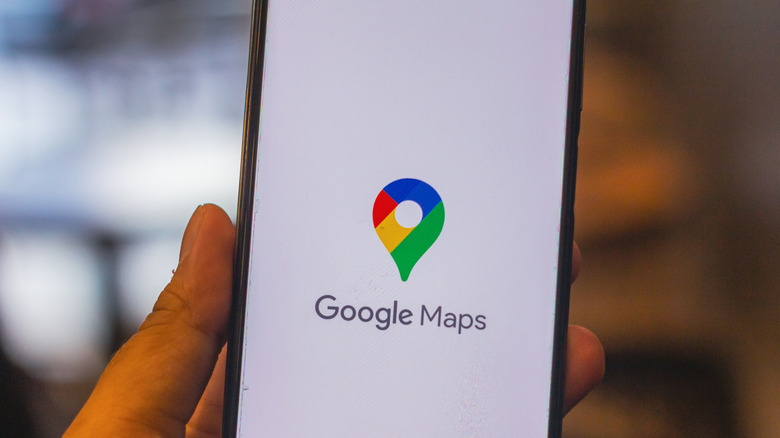 A person holding up a phone with the Google Maps app open.