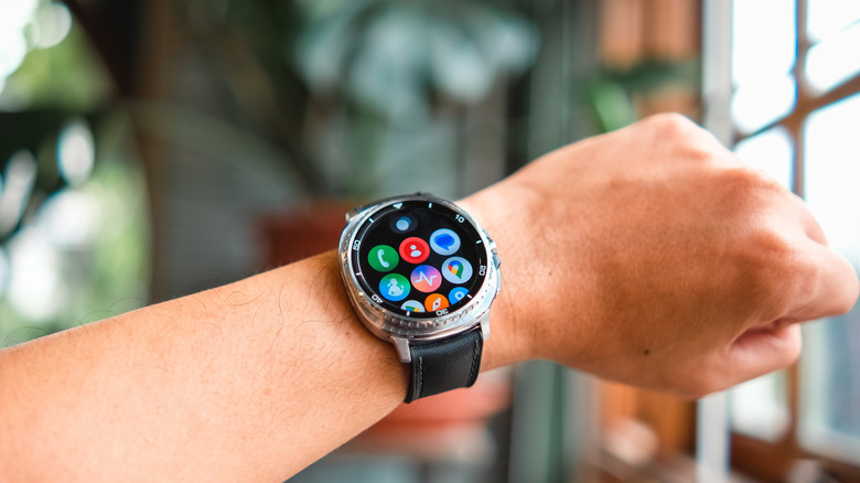A person wearing a Samsung Galaxy Watch 8 classic and showing the home screen.