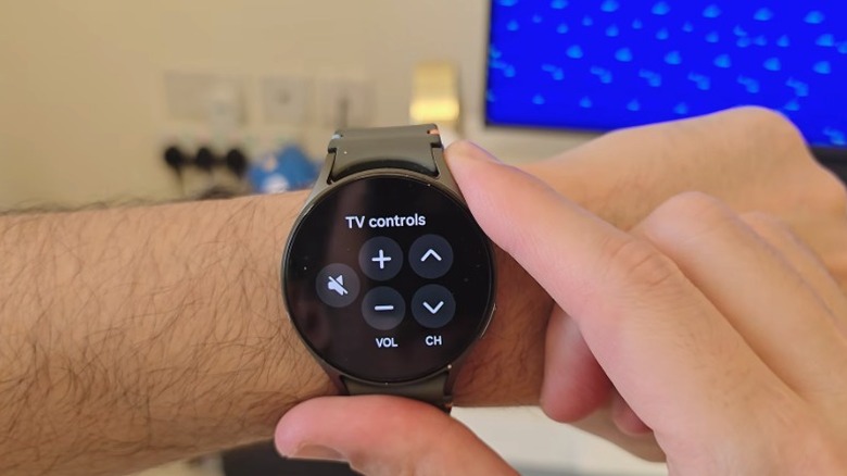A person wearing the Samsung Galaxy Watch 7 open with the Smart Things app open showing the TV controls.