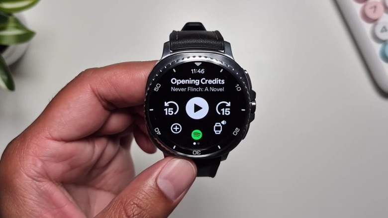A person holding up a Samsung Galaxy Watch 8 Classic with the Spotify app open.