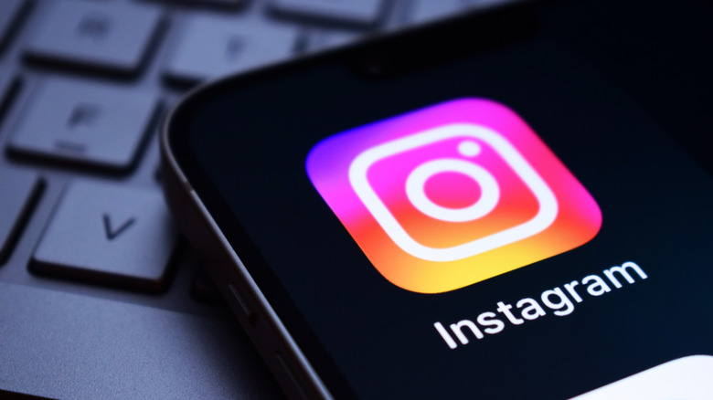 The Instagram logo on a phone, laying on the keyboard