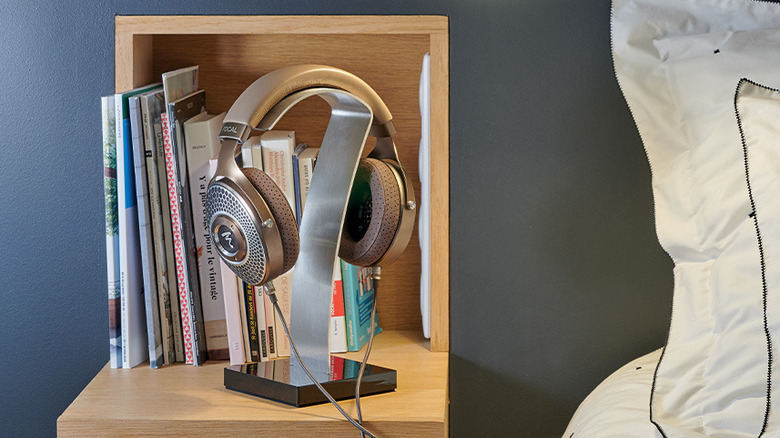 The Focal Clear MG headphones on a headphone stand that's placed on a bedside table