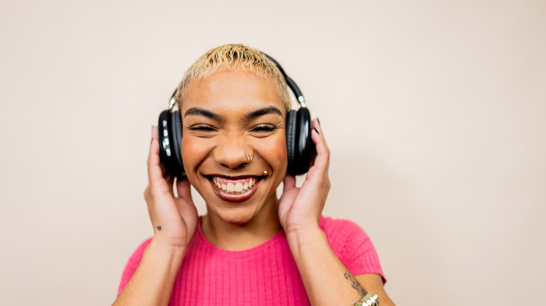 A person smiling while wearing headphones