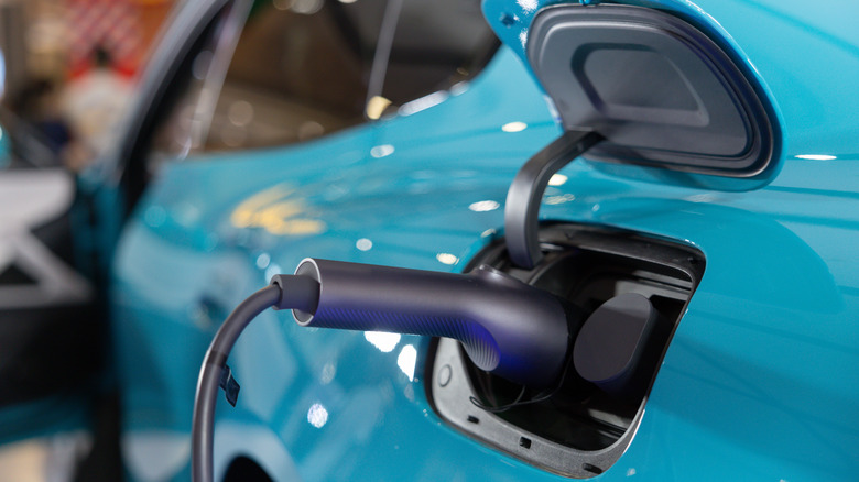 A blue EV being charged