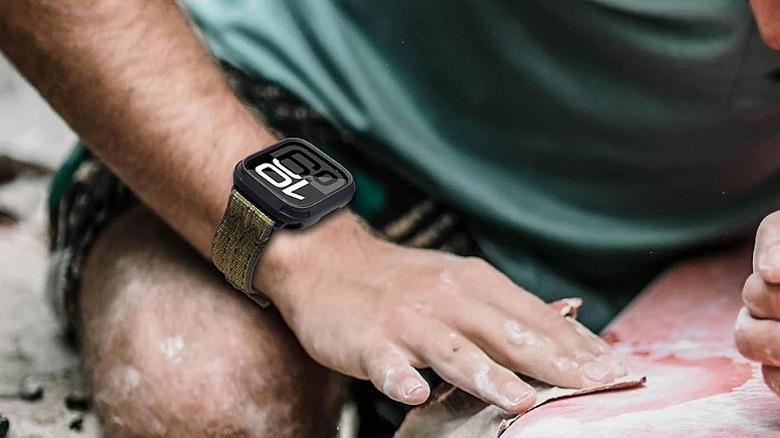 Man wearing a smartwatch outdoors.