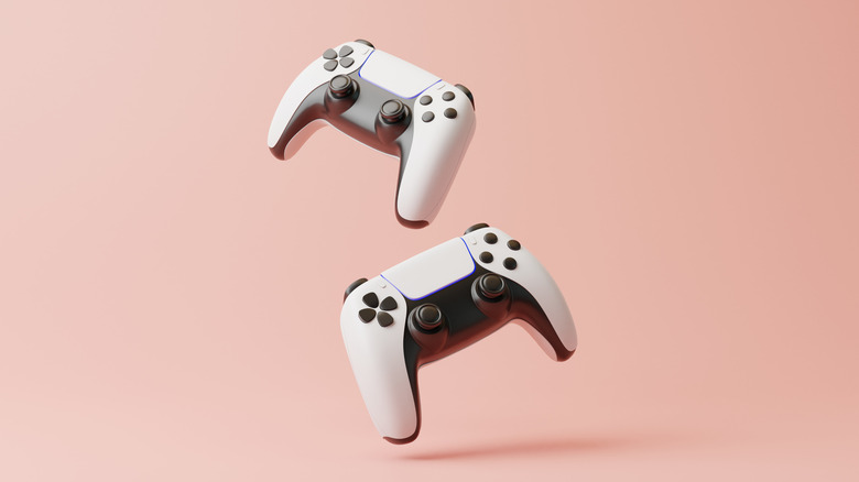 Two DualSense controllers on a pink background
