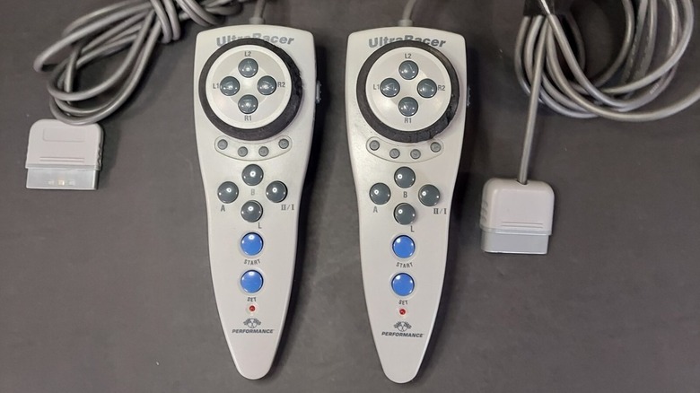 Two UltraRacer PS1 controllers on a gray table