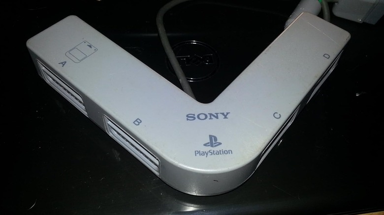 A Sony PS1 multitap placed on a black surface