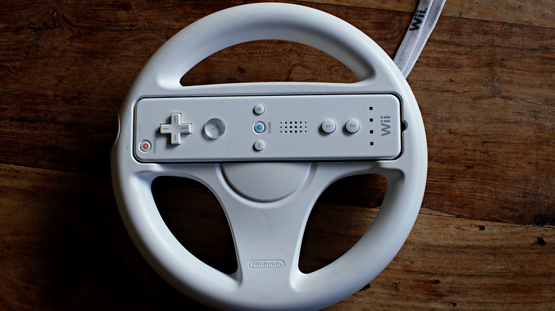 The Wii Wheel with a Wii Remote placed in it, on a wooden surface