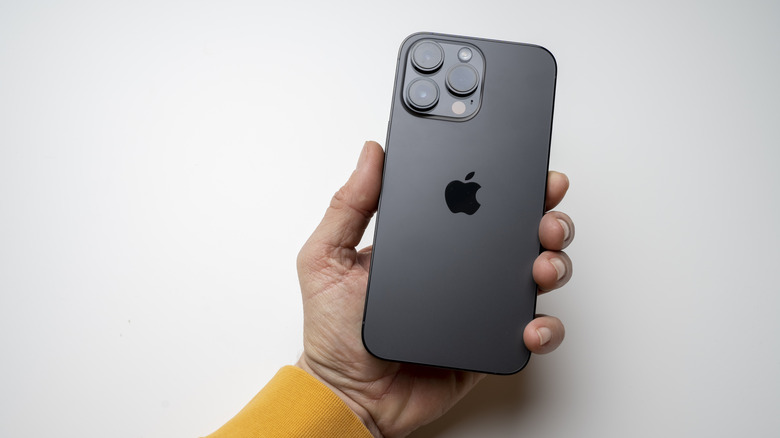 A person holding the iPhone 14 Pro Max in Space Black