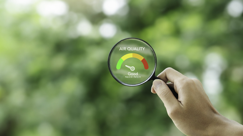 hand holding a magnifying glass to check the good air quality