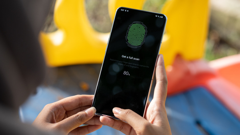 A fingerprint scanner displayed on an Android phone in a person's hands