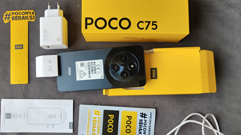 Black Poco C75 smartphone surrounded by packaging and charging accessories