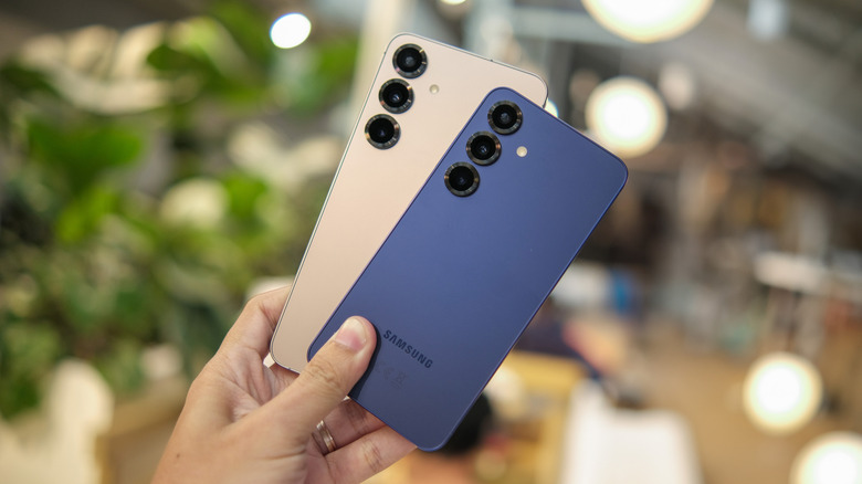 Person holding a Galaxy S25 and a Galaxy S25 Plus in hand