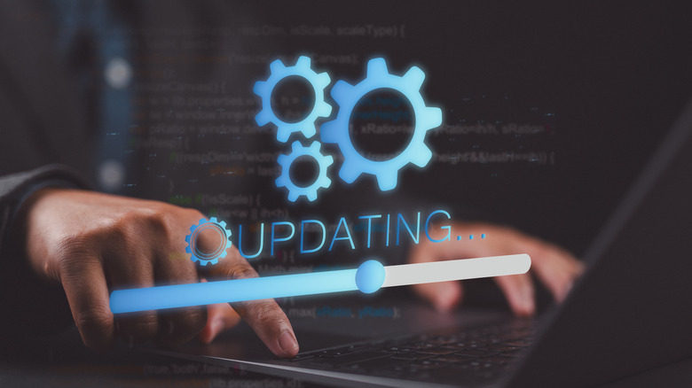 A graphic representing software updates happening on a laptop, with a person typing on the keyboard in the background