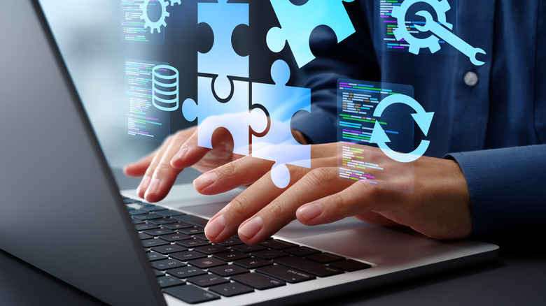 A person typing on their laptop with multiple icons floating over it