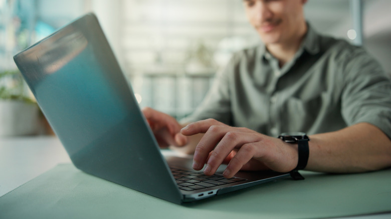 A person typing on their laptop