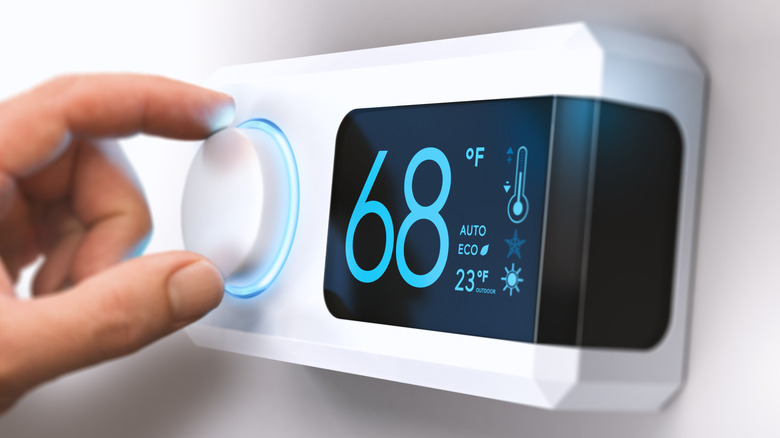 person-setting-temperature-on-thermostat