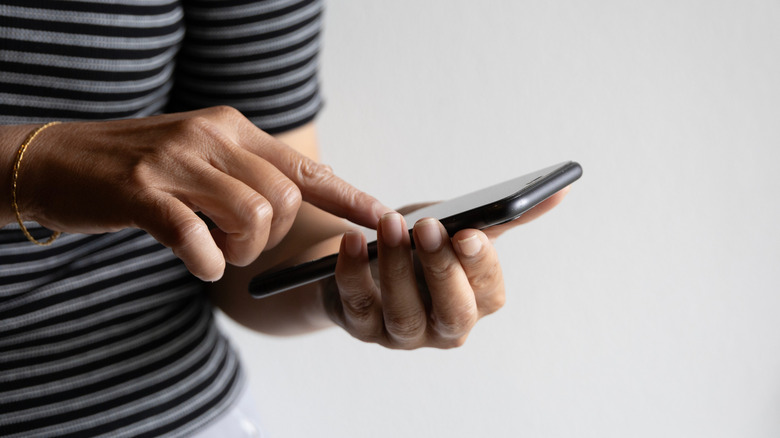 A woman's hands manipulating a smartphone.