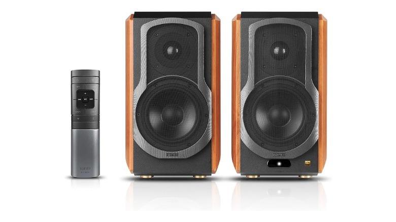 Two speakers, each with one woofer and tweeter next to a remote