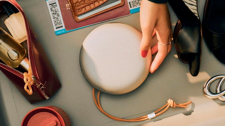 The Bang & Olufsen Beosound A1 (3rd Gen) against an off-white surface with other items.