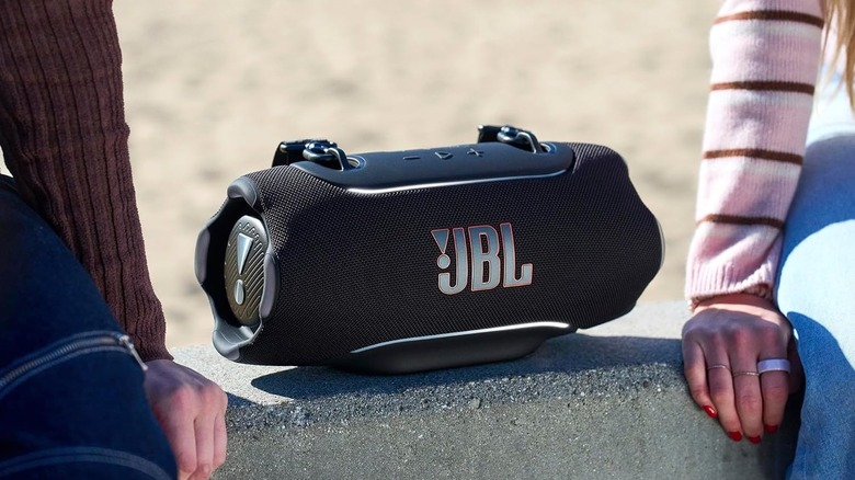 The JBL Xtreme 5 outdoors on a concrete ledge.