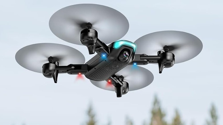 Redrie JY02 hovering with faint trees shown in the background.