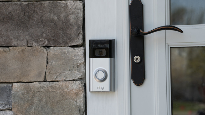 A Ring video doorbell installed next to a front door.