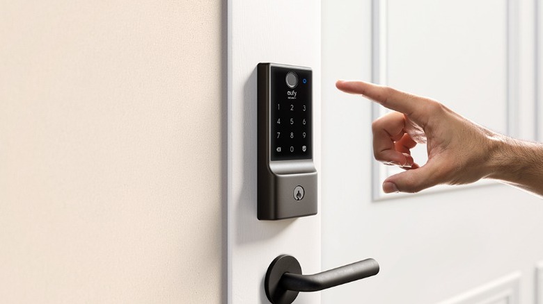 Finger pointing toward a fingerprint sensor on smart door lock